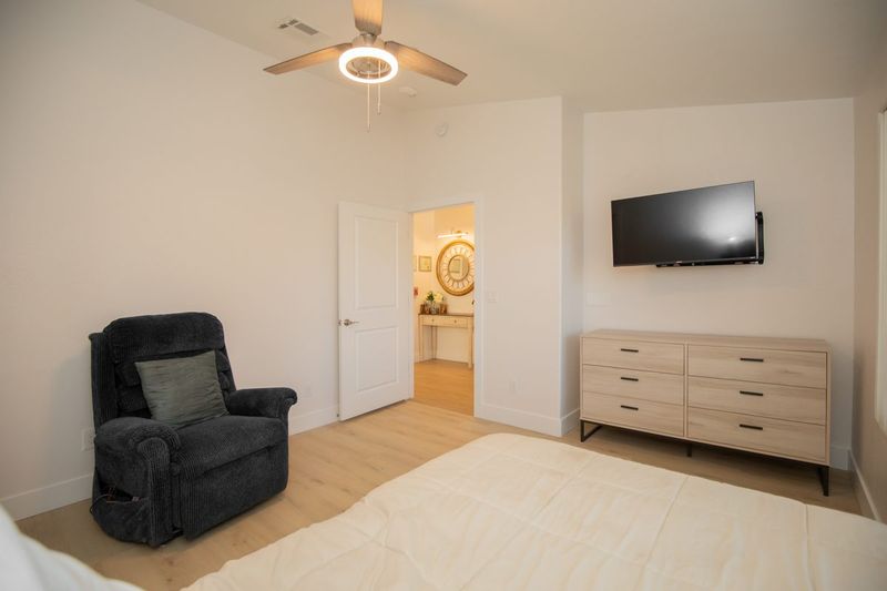 Resident bedroom with a power recliner, dresser, and wall-mounted television